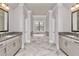 Bright bathroom featuring dual vanities, granite countertops, herringbone floors, and a soaking tub at 1300 Winfair Ne Ln, Brookhaven, GA 30329