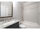 Well-lit bathroom features granite countertops, modern fixtures, and a bathtub with tiled walls at 1300 Winfair Ne Ln, Brookhaven, GA 30329