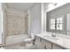 Bathroom featuring a tub with tile surround, white quartz countertop, and large mirror at 1300 Winfair Ne Ln, Brookhaven, GA 30329