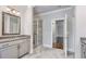 Open bathroom with dual vanities, granite counters, walk-in shower, and stylish tile flooring at 1300 Winfair Ne Ln, Brookhaven, GA 30329