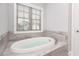 Inviting bathtub with tile surround and a window view, perfect for relaxation at 1300 Winfair Ne Ln, Brookhaven, GA 30329