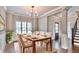 Bright dining room with a chandelier, a large window, and access to the staircase and front door at 1300 Winfair Ne Ln, Brookhaven, GA 30329