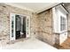 Close-up of the home's entrance featuring a brick facade, a covered porch, and view into the foyer at 1300 Winfair Ne Ln, Brookhaven, GA 30329