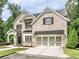 Charming two-story brick home featuring manicured lawn, black shutters, and a convenient two-car garage at 1300 Winfair Ne Ln, Brookhaven, GA 30329