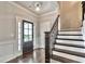 Bright foyer showcasing dark hardwood floors, a staircase with iron spindles, and a striking front door at 1300 Winfair Ne Ln, Brookhaven, GA 30329