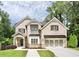 Charming brick home with well-manicured lawn, black window awnings, and attached two-car garage at 1300 Winfair Ne Ln, Brookhaven, GA 30329