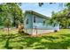 View of the grassy backyard featuring the light blue home with white foundation and a wooden deck at 1317 Bernard Nw St, Atlanta, GA 30314