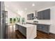 A modern kitchen with gray cabinets, stainless steel appliances, and a large marble island at 1317 Bernard Nw St, Atlanta, GA 30314