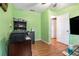 Office space featuring bright green walls and wood floors with a printer and small refrigerator at 3392 Inns Brook Way, Snellville, GA 30039