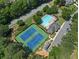 Aerial view of a community pool, tennis courts, and clubhouse shows ample parking and mature landscaping at 858 Red Rock Ct, Suwanee, GA 30024