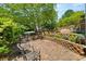 Backyard with stone seating, lush greenery, and manicured landscaping at 858 Red Rock Ct, Suwanee, GA 30024