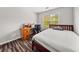 Neat bedroom features a wooden-frame bed, desk, and hardwood floors at 858 Red Rock Ct, Suwanee, GA 30024