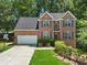 Charming two-story brick home with a well-maintained lawn, attached garage, and a basketball hoop at 858 Red Rock Ct, Suwanee, GA 30024
