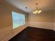 Elegant dining room featuring classic wainscoting, dark wood floors, and a stylish chandelier at 330 Kentwood Springs Dr, Hampton, GA 30228
