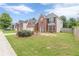 Suburban home with brick facade, two-car garage, and lush green lawn at 330 Kentwood Springs Dr, Hampton, GA 30228