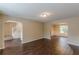 Open-concept living room featuring hardwood floors, archways, and neutral paint at 330 Kentwood Springs Dr, Hampton, GA 30228