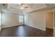Main bedroom with a tray ceiling, ceiling fan, wood-look floors and a view to an adjoining bathroom at 330 Kentwood Springs Dr, Hampton, GA 30228