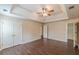 Main bedroom featuring wood-look floors, a tray ceiling, and a ceiling fan at 330 Kentwood Springs Dr, Hampton, GA 30228