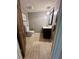 A neutral-toned bathroom features modern lighting, clean lines, and wood-look tile flooring at 4506 Town Crier Sw Rd, Lilburn, GA 30047