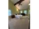 Bedroom featuring a vaulted ceiling with a fan, neutral carpet, and windows at 4506 Town Crier Sw Rd, Lilburn, GA 30047