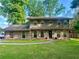Charming two-story home with stone accents, manicured lawn, and lush trees at 4506 Town Crier Sw Rd, Lilburn, GA 30047