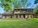 Charming two-story home featuring stone accents, a well-manicured lawn, and mature trees at 4506 Town Crier Sw Rd, Lilburn, GA 30047