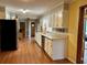 Spacious kitchen featuring white cabinetry, stainless steel appliances, and wood-look floors at 4506 Town Crier Sw Rd, Lilburn, GA 30047