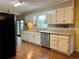 A spacious kitchen boasts wood floors, white cabinets, and stainless-steel appliances at 4506 Town Crier Sw Rd, Lilburn, GA 30047