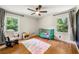 Cozy bedroom with wood floors, two windows, ceiling fan, and green baby bed at 5290 River Mill Cir, Marietta, GA 30068