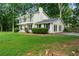 Charming white home featuring a double-decker balcony, lush lawn, and mature trees at 5290 River Mill Cir, Marietta, GA 30068