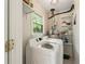 Laundry room with new washer and dryer, storage shelves, and a window for natural light at 5290 River Mill Cir, Marietta, GA 30068