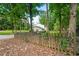 Yard enclosed by a rustic wooden fence with green lawn surrounded by tall trees at 5290 River Mill Cir, Marietta, GA 30068