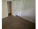 Bedroom featuring carpet flooring, and a closet with folding doors for storage at 5924 Central Church Rd, Douglasville, GA 30135