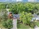 Aerial view of a brick home with mature trees and a well-manicured lawn in a quiet neighborhood at 10400 Groomsbridge Rd, Alpharetta, GA 30022