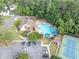 Aerial view of a community center featuring a pool, clubhouse, tennis court, parking, and surrounding greenery at 10400 Groomsbridge Rd, Alpharetta, GA 30022