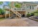 Lovely backyard with a brick paver patio and a stairway leading to an upper deck at 10400 Groomsbridge Rd, Alpharetta, GA 30022