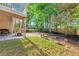 Well-maintained backyard featuring a lush lawn, mature trees, and a stone patio area at 10400 Groomsbridge Rd, Alpharetta, GA 30022