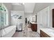 Modern bathroom featuring a free standing tub, double vanities, a shower, and an arched window at 10400 Groomsbridge Rd, Alpharetta, GA 30022