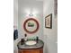 Charming half bathroom features a round decorative mirror and a granite topped vanity at 10400 Groomsbridge Rd, Alpharetta, GA 30022