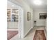 Hallway view with hardwood floors, base molding, rug, and storage room with white shelving and storage at 10400 Groomsbridge Rd, Alpharetta, GA 30022