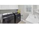 Convenient laundry room with washer, dryer, sink and white cabinets for storage at 10400 Groomsbridge Rd, Alpharetta, GA 30022