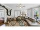 Open concept living room with hardwood floors, large windows, comfortable seating, and backyard views at 10400 Groomsbridge Rd, Alpharetta, GA 30022