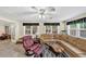 Large living room with plenty of seating, windows and access to the basement area with a drum set at 10400 Groomsbridge Rd, Alpharetta, GA 30022