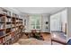 Inviting living room featuring hardwood floors, a large window, and a full bookshelf at 10400 Groomsbridge Rd, Alpharetta, GA 30022