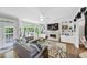 Bright living room with a large sofa, fireplace, built-ins and backyard views at 10400 Groomsbridge Rd, Alpharetta, GA 30022