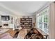 Cozy living room featuring hardwood floors, a large window, and a built-in bookshelf at 10400 Groomsbridge Rd, Alpharetta, GA 30022