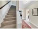 Carpeted stairs lead to the upper level with neutral walls and trim, and a decorative rug at 10400 Groomsbridge Rd, Alpharetta, GA 30022