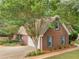 Aerial view of a brick home, a garage, landscaping, and mature trees in a residential neighborhood at 1585 Lake Dow Rd, Mcdonough, GA 30252