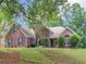 Charming brick home with well-manicured lawn, mature trees, and inviting front entrance at 1585 Lake Dow Rd, Mcdonough, GA 30252