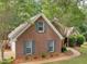 Brick home with dormer windows, attached garage, and a well-manicured front yard with green shutters at 1585 Lake Dow Rd, Mcdonough, GA 30252